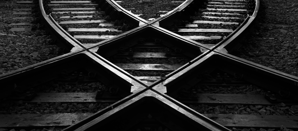 Black and white image of train tracks criss crossing like an X